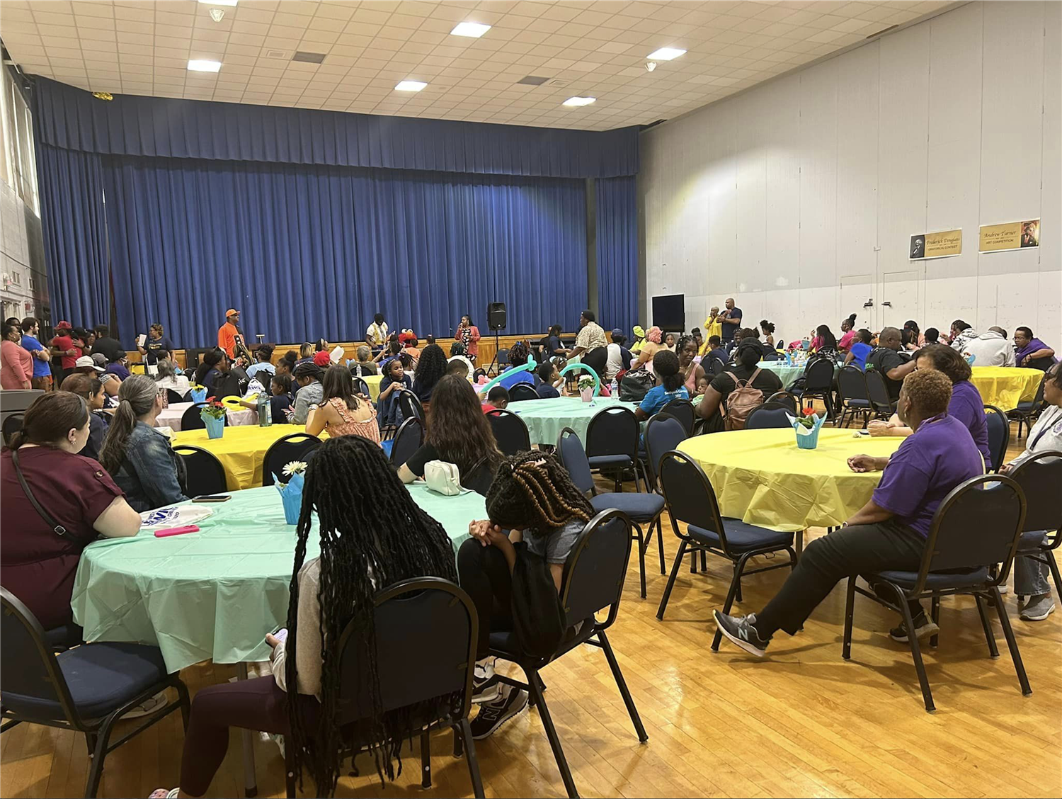 Parents & community members gather in the auditorium of STEM Academy around round tables